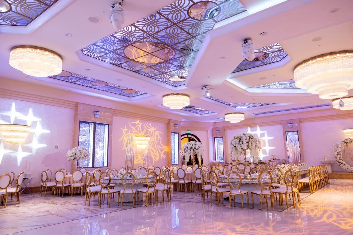 Wedding reception ballroom with gold chairs